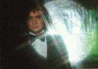 michel sardou, en costume concert peut etre, fond noir, contraste clair blanc jeux de lumières : image qui rend bien: jolie ;  ainsi que  ses   chansons  qui resteront encore longtemps dans l'esp
