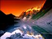beau coucher de soleil orangé jaune, la nuit , la lune qu'on ne voit pas,mais on l'imagine, qui éclairent: montagnes,vallées enneigées, très jolie , inspirant aussi à la BEAUTE  du REGARD ; 
