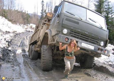 c'est ps une SuperWoman mais presque! pr soulever ce camion, sur les routes enneigées, neige montagne ;joli   et   amusant  cmme image: montre aussi  la  force  de la  femme   -dans l'image 
