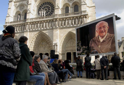 Messe en hommage &agrave;  Soeur Emmanuelle devant le Parvis de NOTRE DAME DE PARIS, des personnes dehors, la c&eacute;r&eacute;monie &agrave; l'int&eacute;rieur, un &eacute;cran g&eacute;ant pr montre le visage souriant de cette grande dame qu