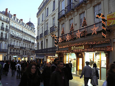 A Montpellier,Rue de la Loge donne sr Place de la Com&eacute;die,foule , le temps des f&ecirc;tes NOEL  FIN D'ANNEE  Guirlandes, boutiques &eacute;clair&eacute;es d&eacute;cor&eacute;es � Plus d'ambiance animation comm ttes les vil